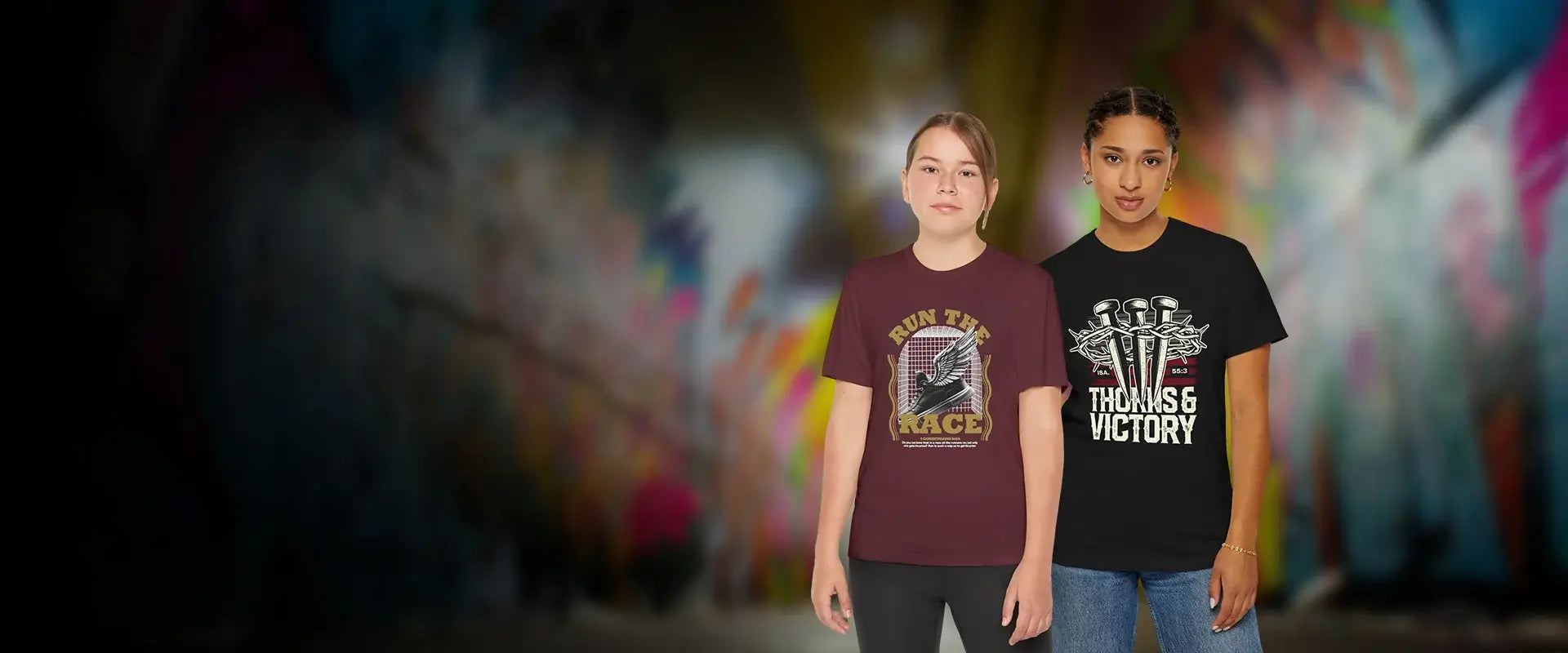 Two people wearing t-shirts with graphic designs in front of a colorful, blurred background