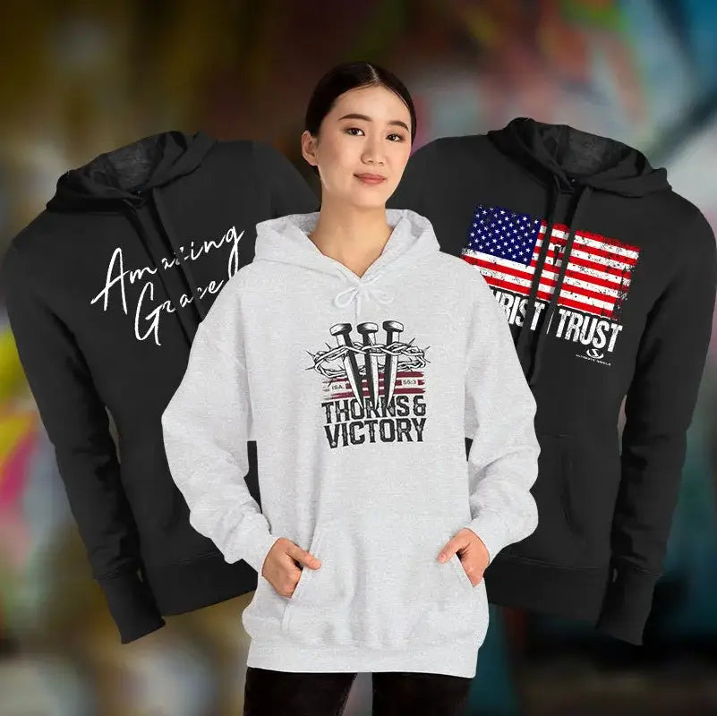 Woman wearing a white hoodie with motivational text, flanked by black hoodies with different designs.